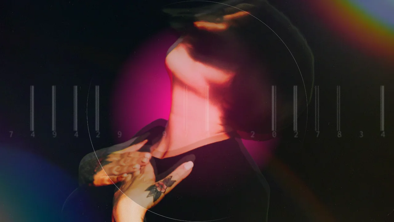 an ethereal image of a blurry woman looking to the left, looking up to the sky with her hands on her heart. reject the machine in white text is across the centre of the image. april 23 is in white text at the bottom centre of the image. behind the woman is a pink orb, and the background is black with rainbow lens flares at the top right and bottom left.
